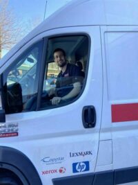 Reach Technologies Personnel Driving A Van for Printer Repair